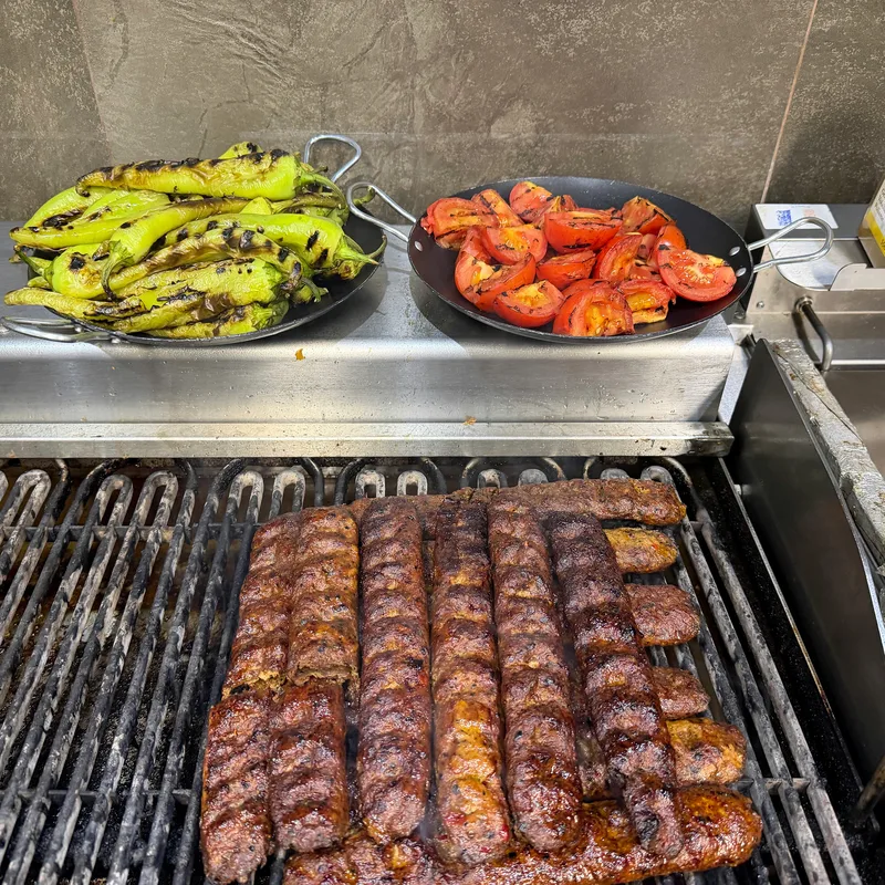 Köfte, Peperoni und Tomaten auf dem Grill in der Küche