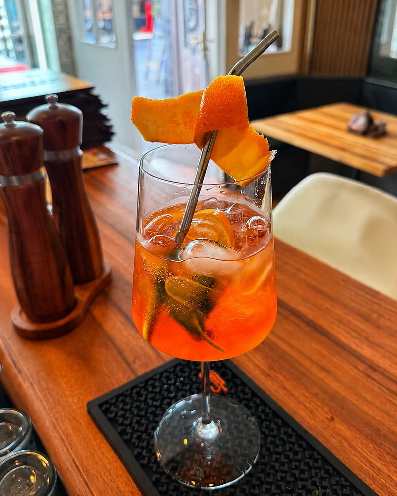 Aperol Spritz mit Orangenzeste an der Bar