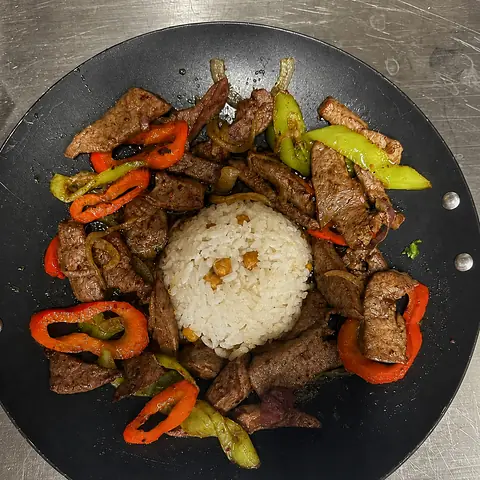 Rindfleischstreifen mit Paprika aus dem Wok, dazu Reis