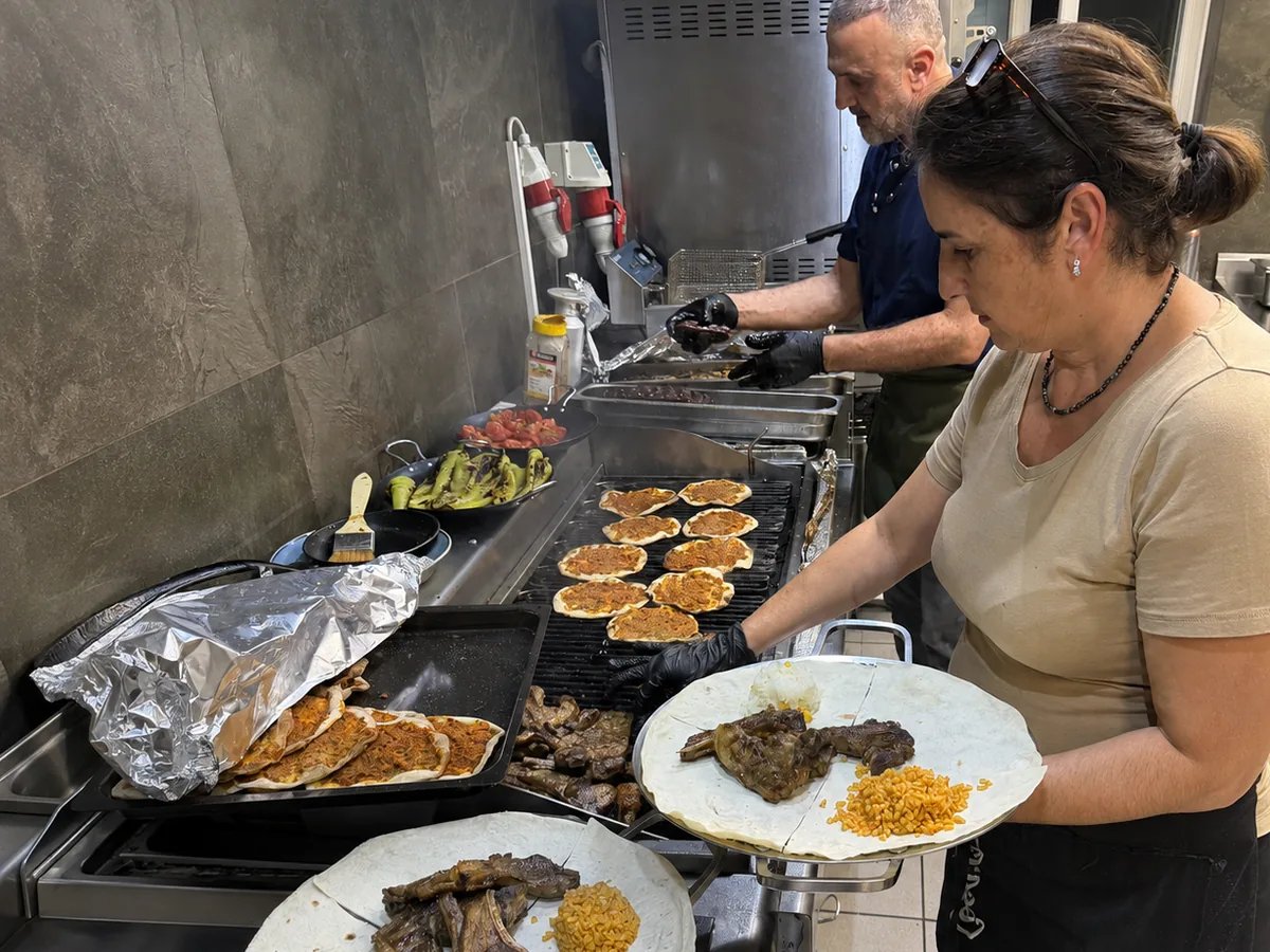 Unsere Köchin richtet einen Grillteller an – im Hintergrund Lahmacun auf dem Grill